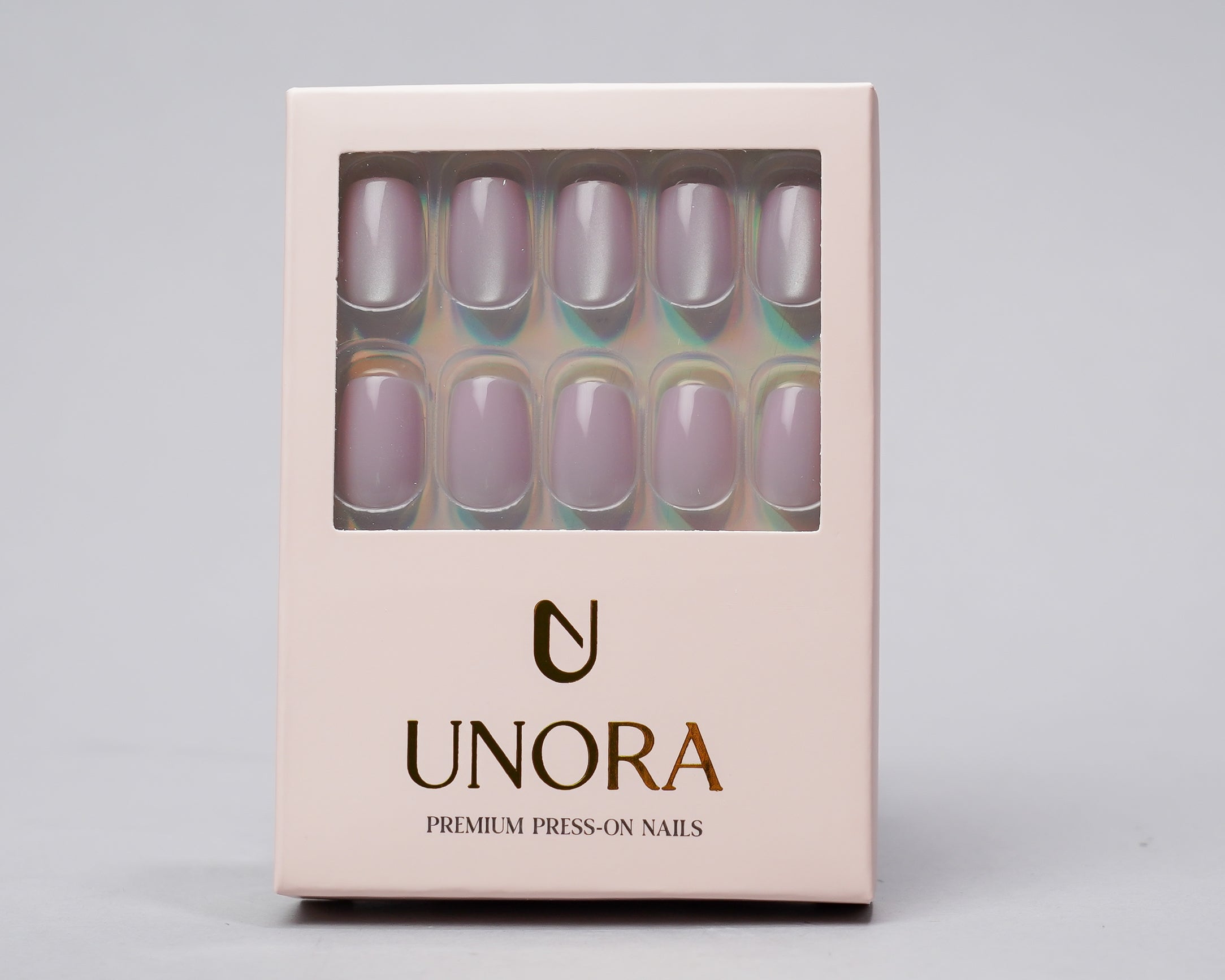 UNORA press-on nail set in a pale pink rectangular box with a clear window showing lavender iridescent nails, on a light gray background.