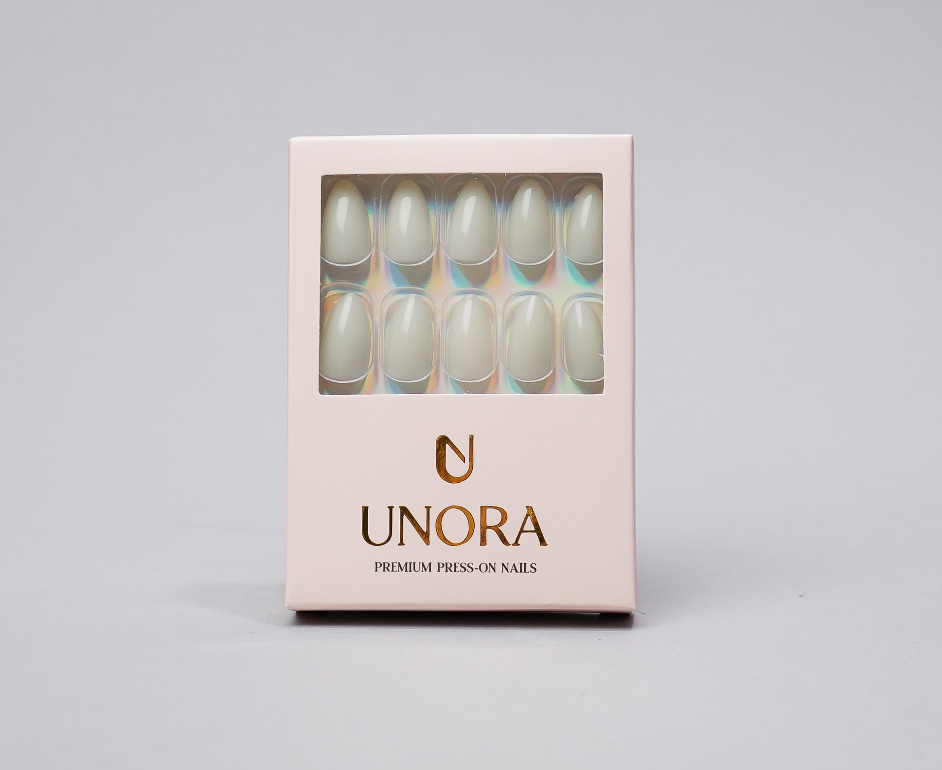 UNORA press-on nails in a pale pink rectangular box with a clear window showing ten almond-shaped nails with a glossy pearlescent finish.